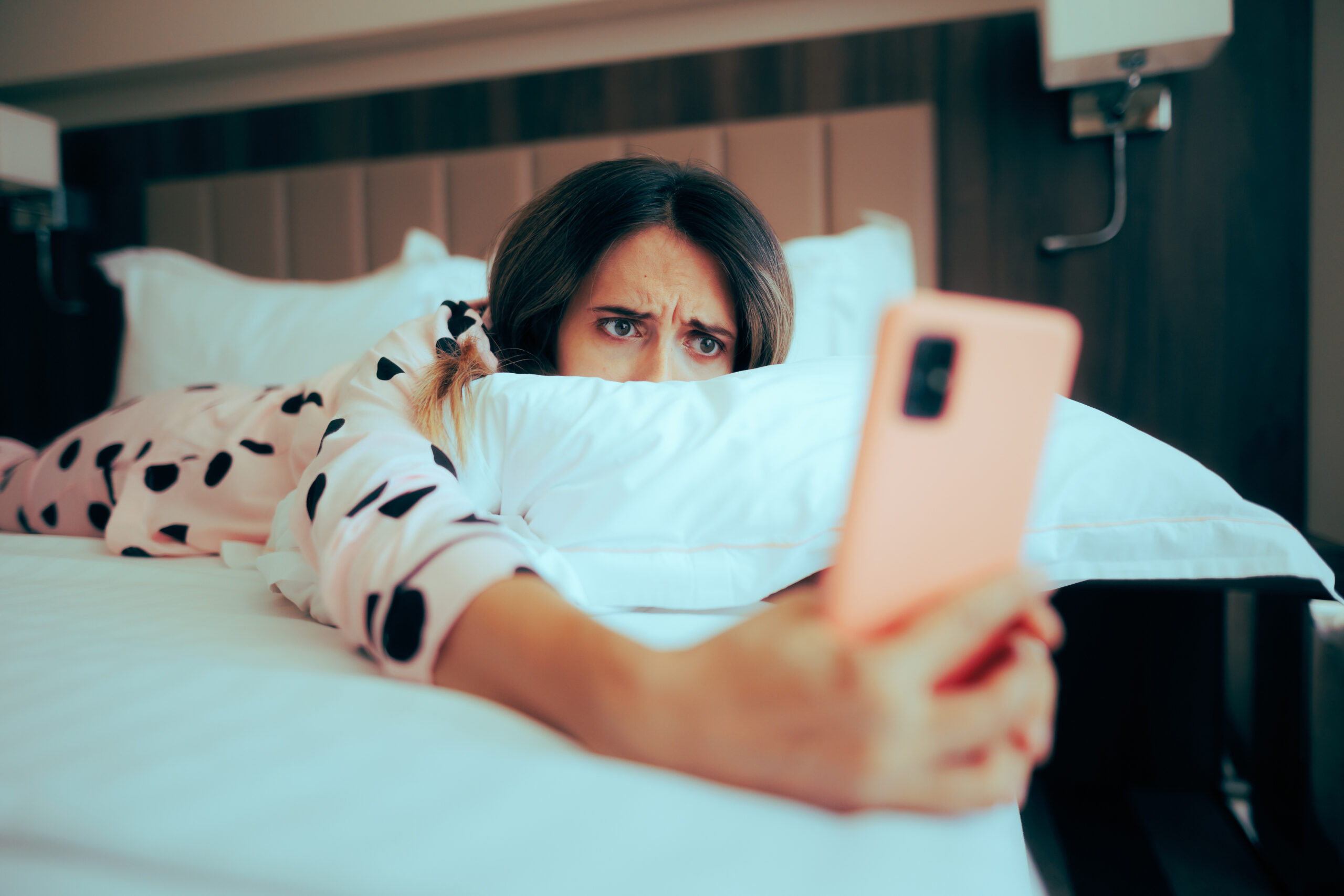 laying in bed woman laying in the beg on her phone